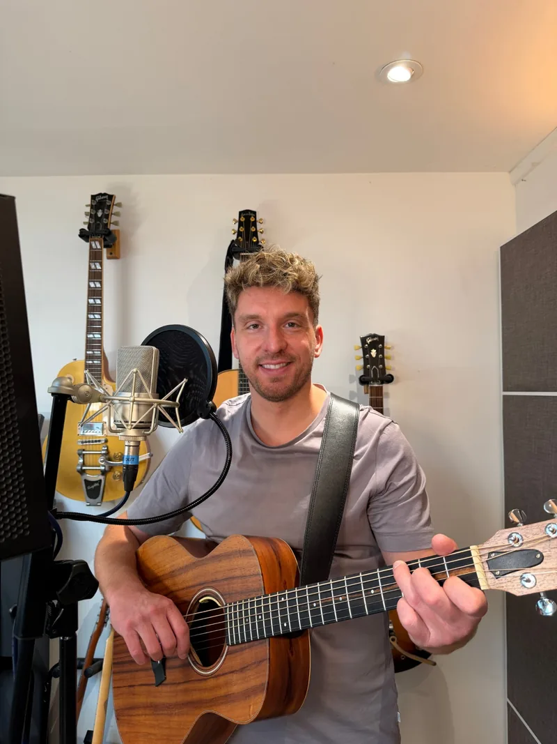 Tom Ryder with an acoustic guitar