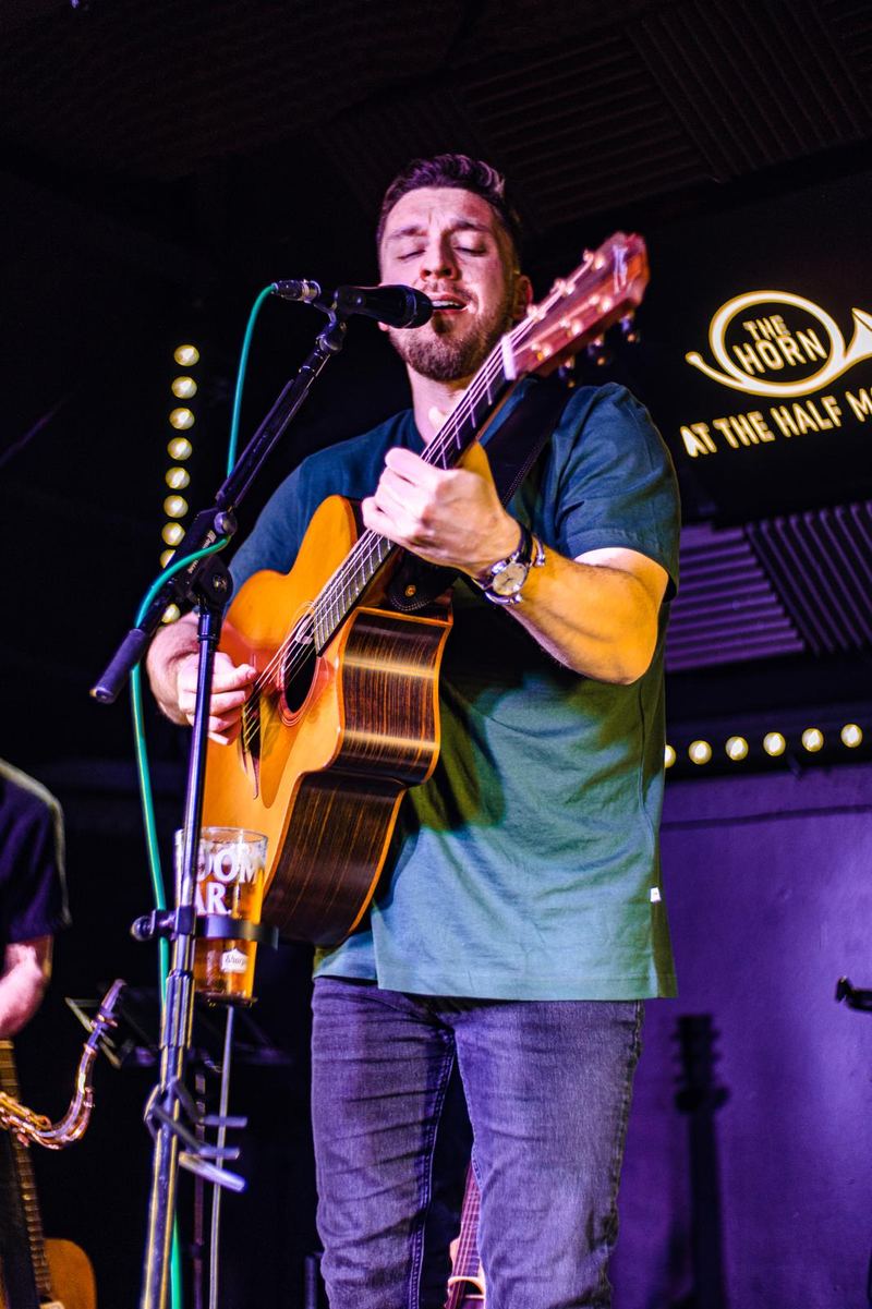 Tom on stage under purple lights